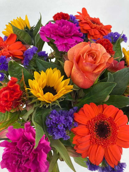 Bright posy consisting of orange, yellow, red, purple, and green flowers up close