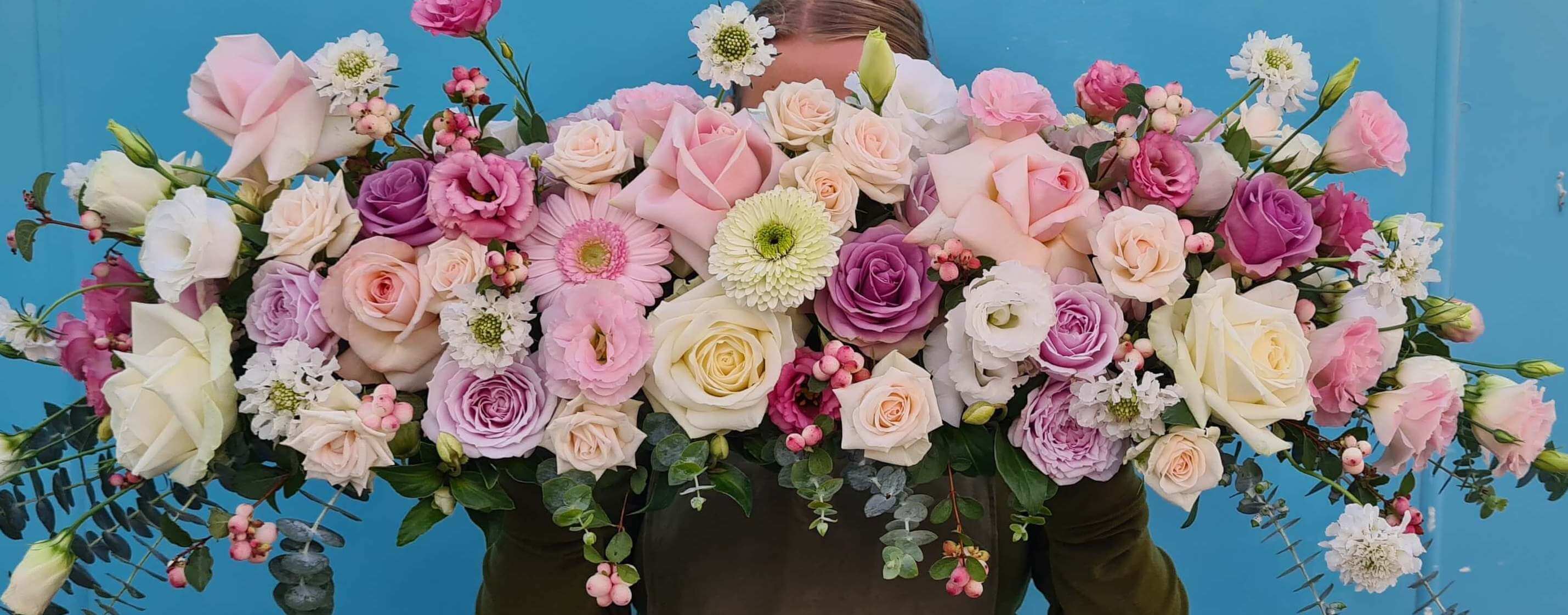 Pink, purple, white, and green flowers make this wedding table flower arrangement.