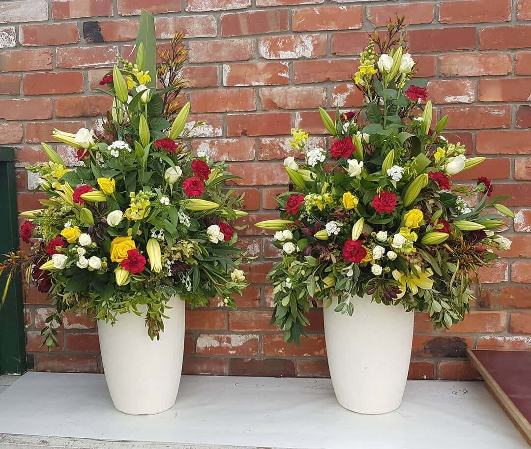 Red, green, and yellow flower arrangement we made for a corporate event