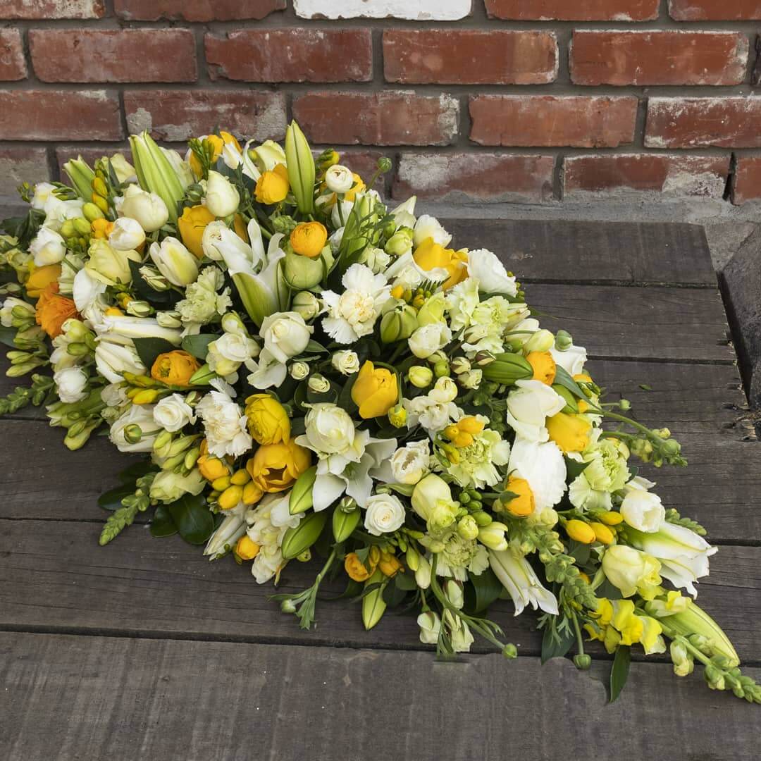 Yellow, green, and white casket spray funeral flower arrangement